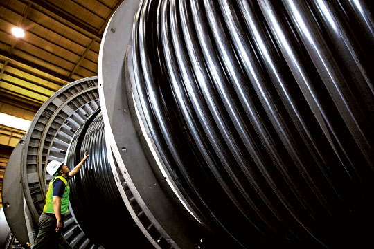 LS전선은 덴마크 국영 에너지 기업인 외르스테드의 풍력발전 단지 조성 사업인 '혼시' 프로젝트2'를 위한 초고압 케이블 공급 계약을 체결했다고 1일 밝혔다. LS전선 직원이 생산된 초고압 케이블을 점검하고 있는 모습. <LS전선 제공>